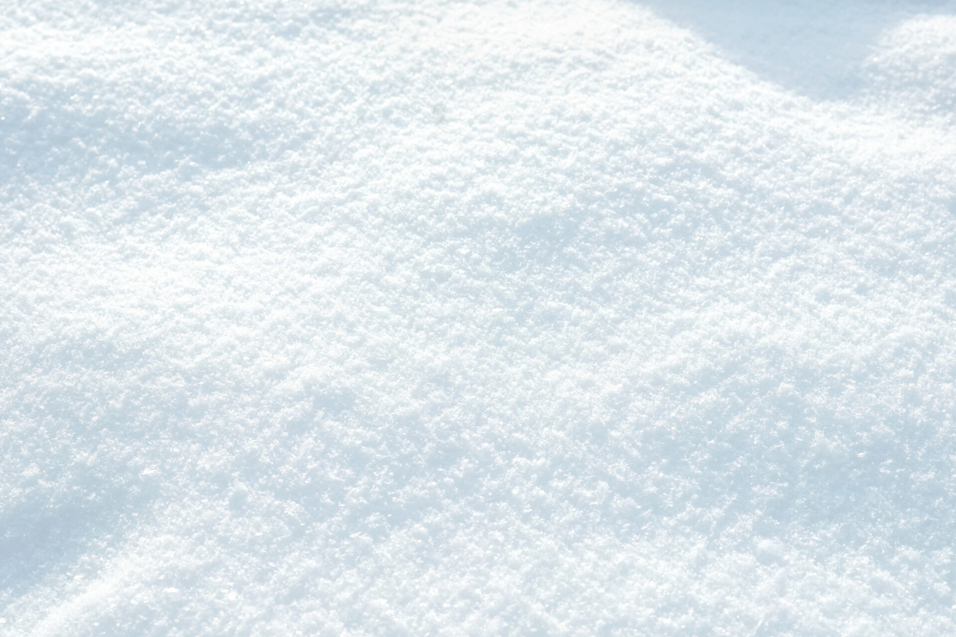 The image shows a close-up of freshly fallen snow, displaying a smooth and pristine white surface. No landmarks or historical buildings are visible.